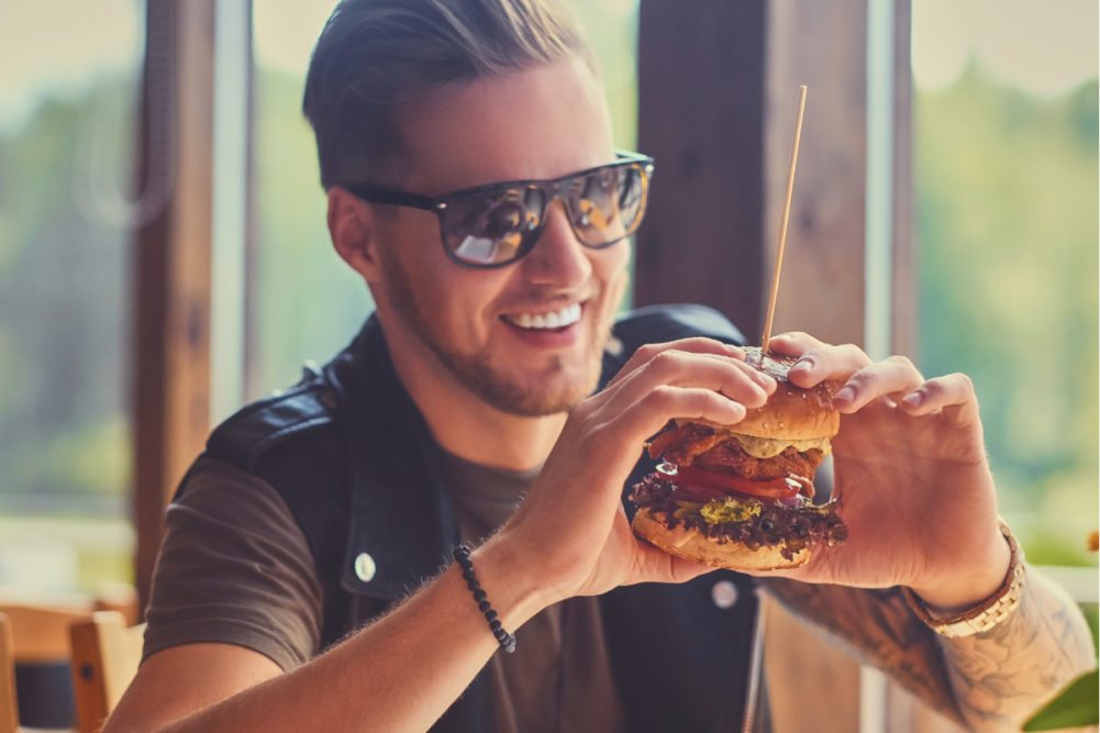 Millennial eating plant-based burger