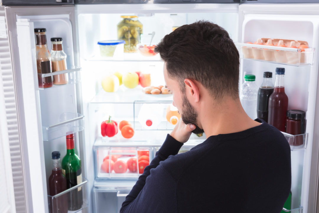 Man looking in fridge wondering what's for dinner