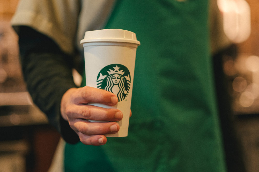 Starbucks barista holding Starbucks coffee cup