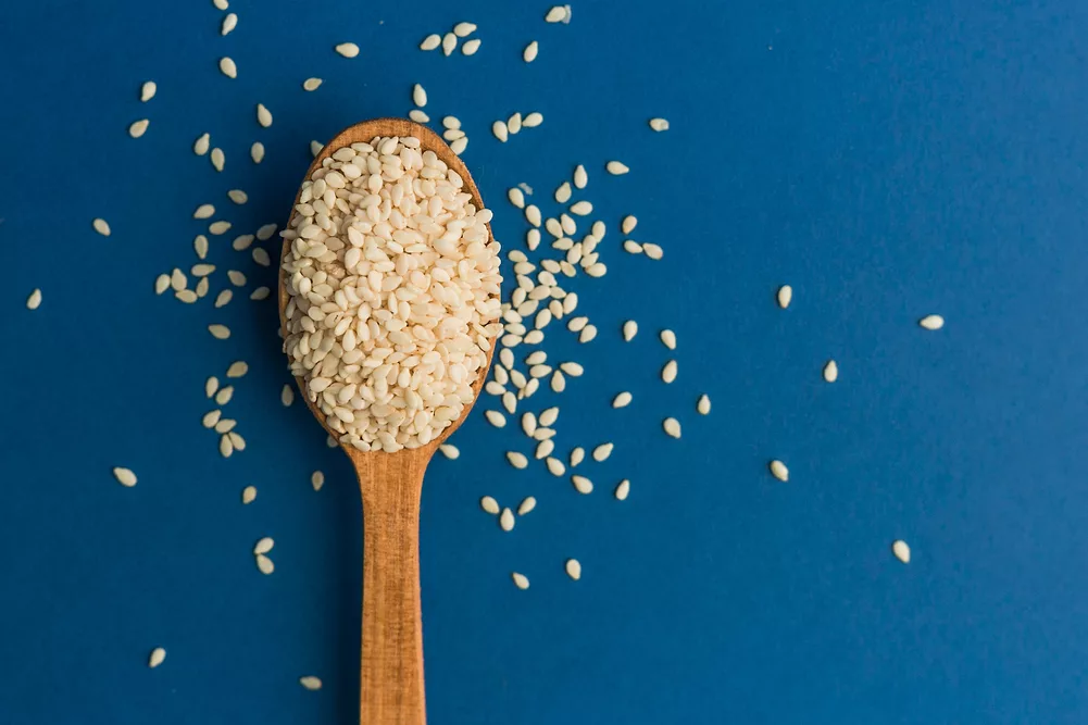 Wooden spoon full of sesame seeds