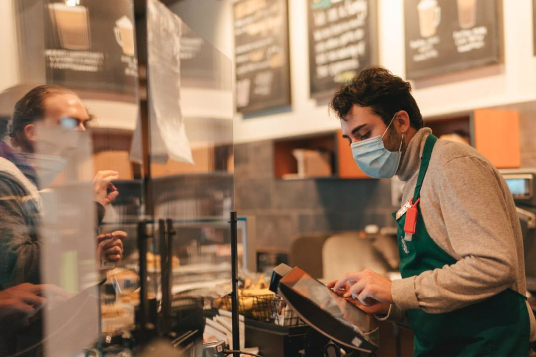 Starbucks employee in mask taking coffee order