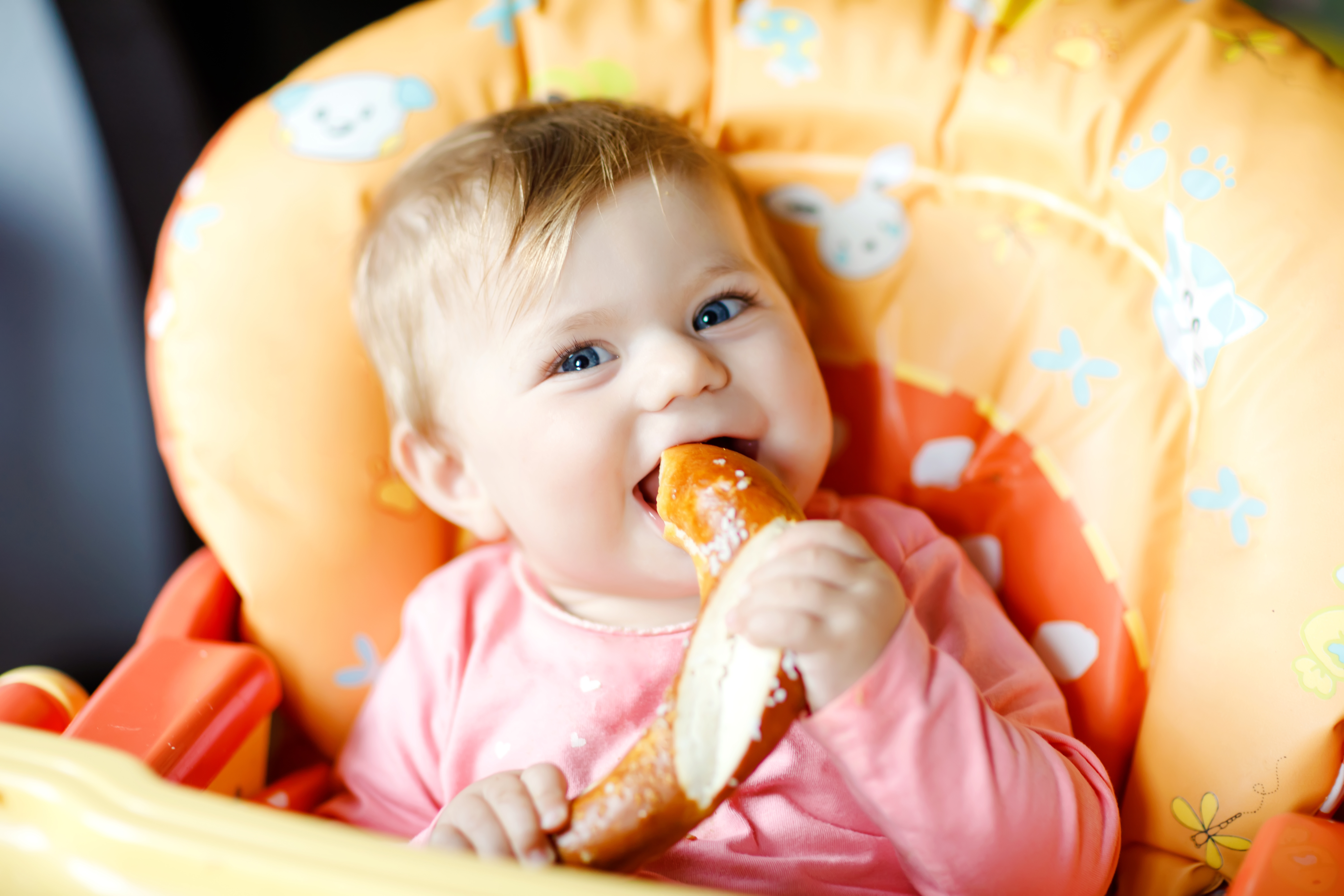 baby eating a soft pretzel
