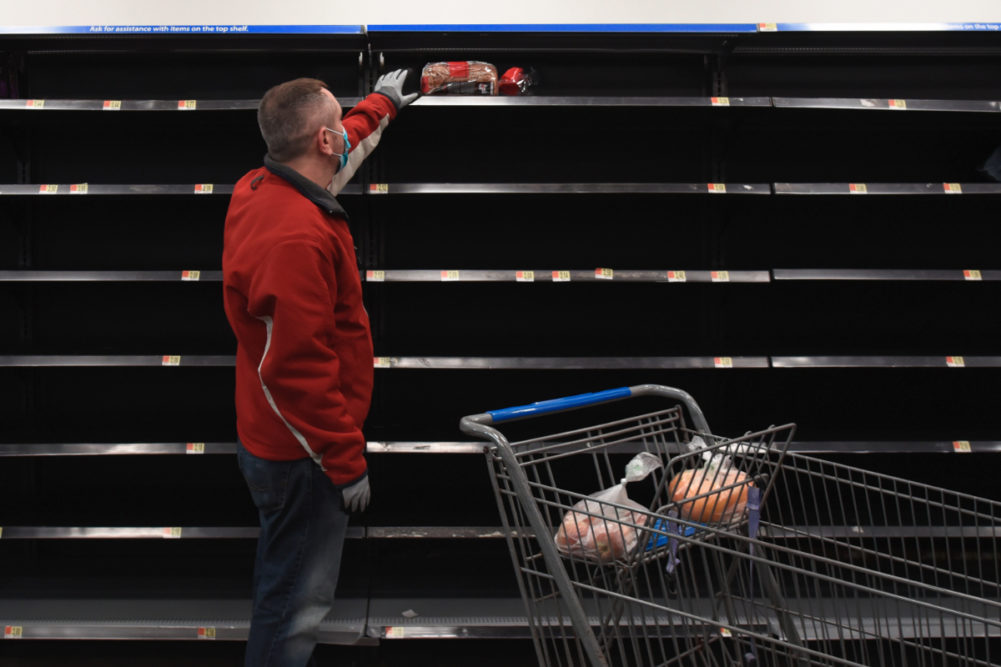 Man shopping for bread amid empty shelves due to coronavirus