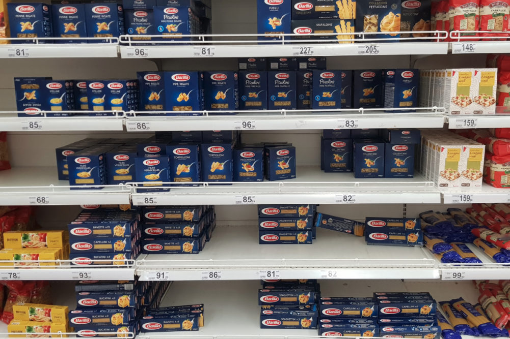 Half-empty shelves with pasta due to coronovirus in a supermarket