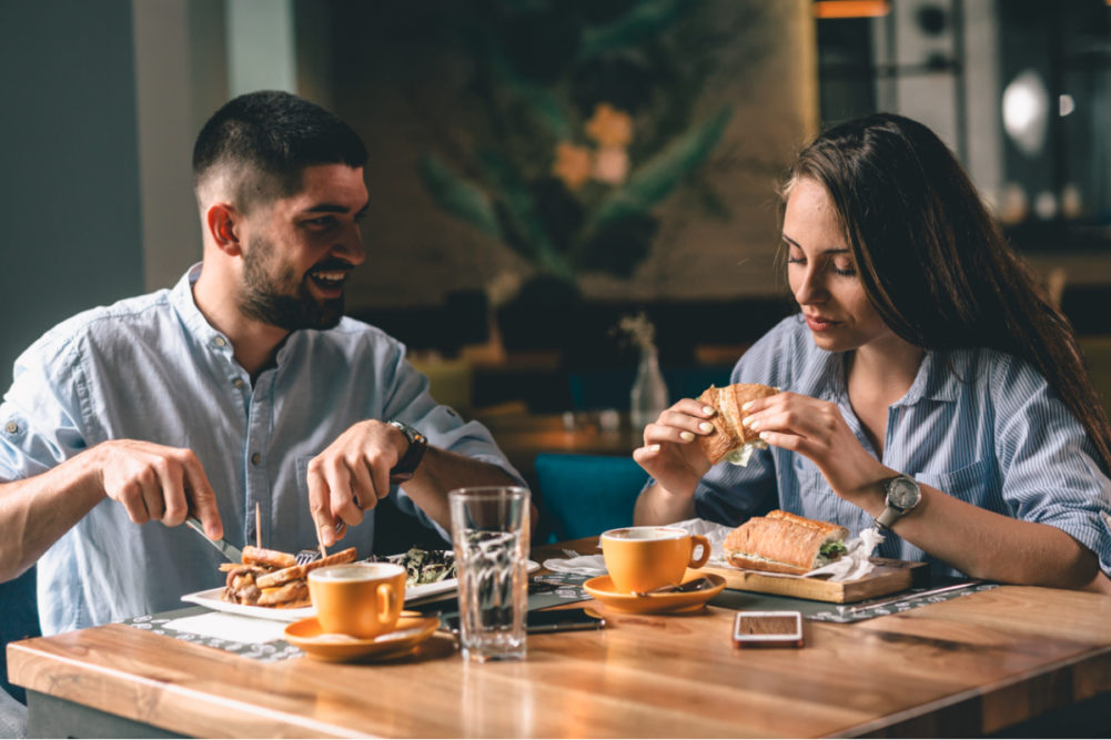 Couple eating at restaurant with full attribution