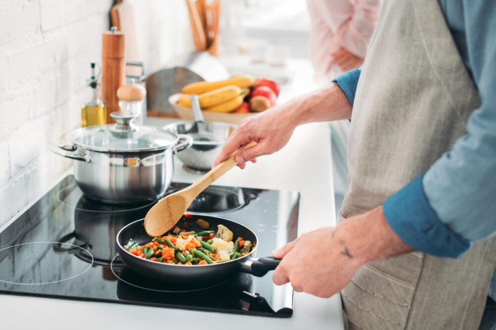 Man frying vegetables