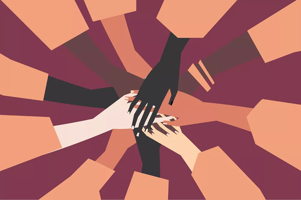 Human hands with different skin color stacked together for support. 