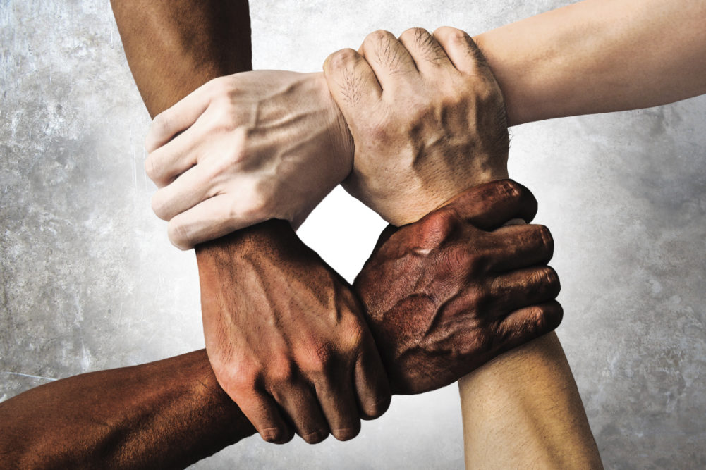Multiracial hands linked together