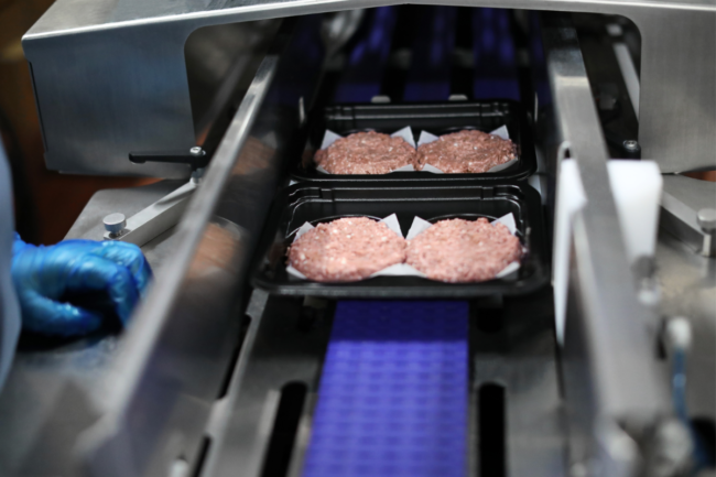 Beyond Meat burgers in trays on manufacturing line