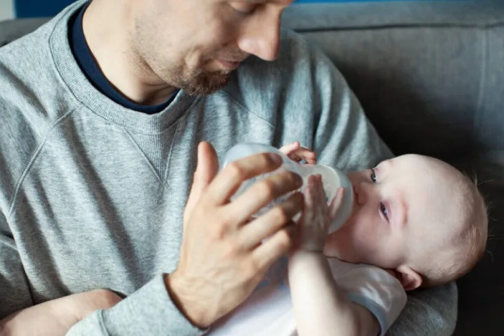 Man feeding baby with bottle