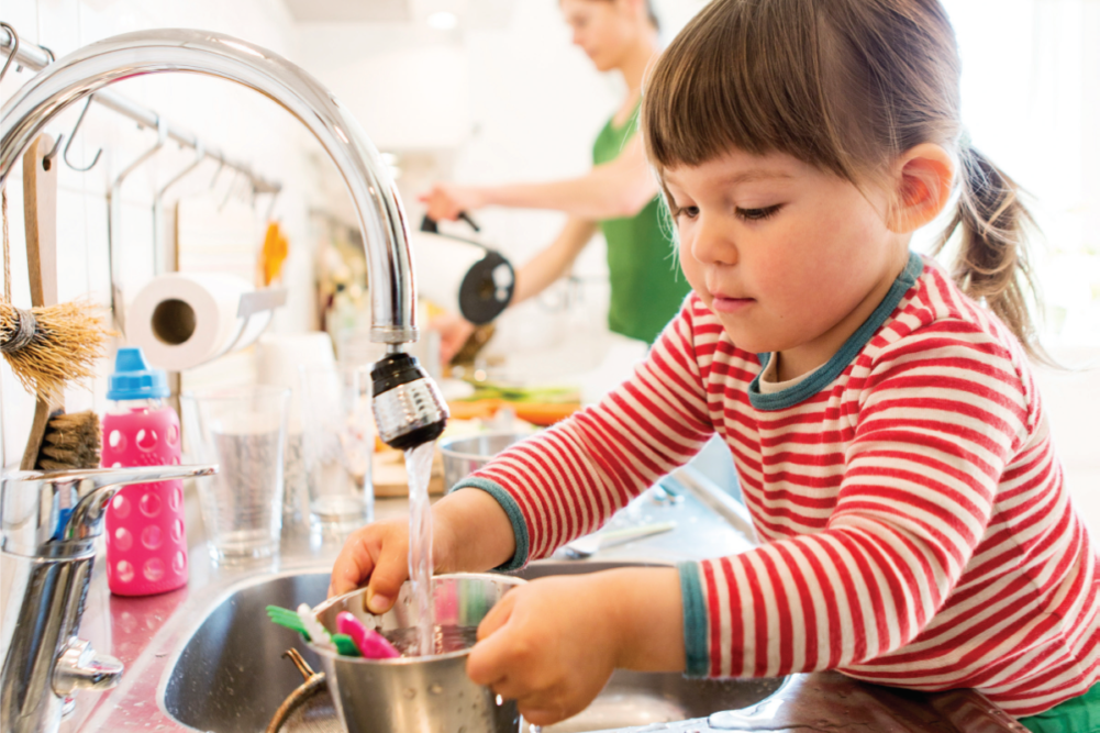 Child helping parents in the kitchen