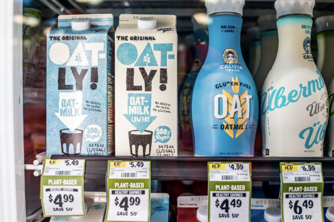 Sprouts Farmers Market grocery store interior shelf packaged retail display of vegan plant-based health food Oat-ly milk on sale