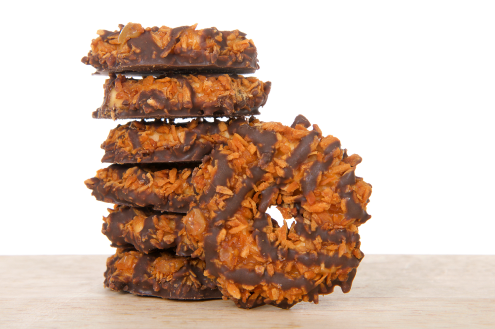 Samoas cookies on a wood table with white background