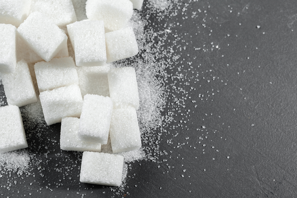 White sugar cubes over black background