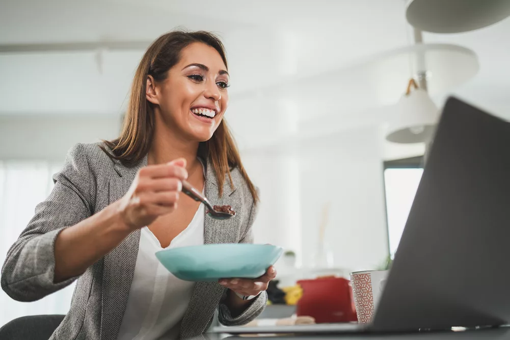 Woman eating in front of a laptop