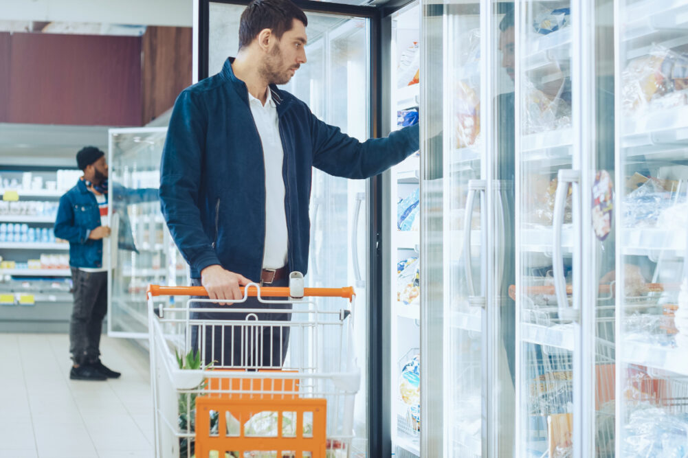 Men shopping in the frozen aisle at the supermarket