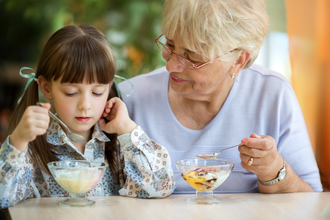 child and grandmother eating yogurt