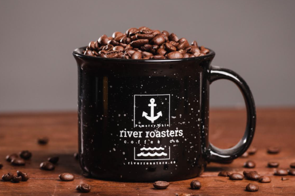 coffee cup filled with coffee beans featuring River Roaster Coffee's logo