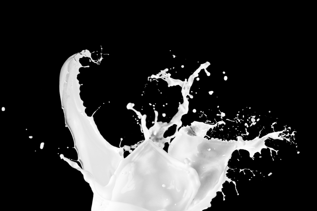 Liquid milk on black background