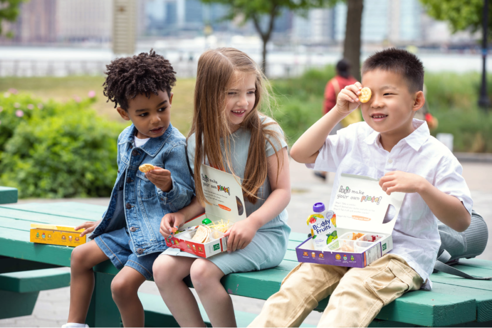 Children eating plant-based lunch kits from Lets Plate