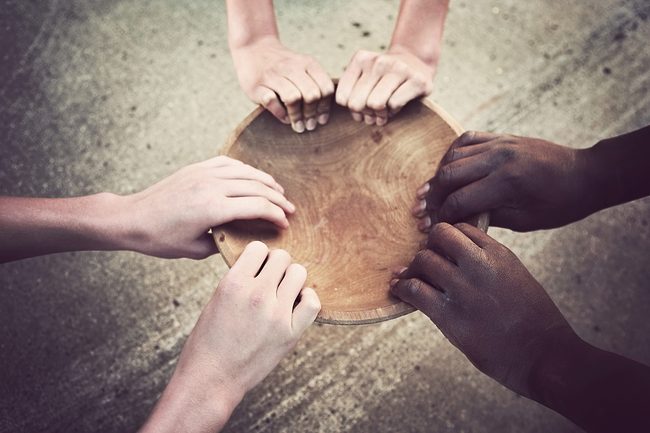 Hands of hungry people holding empty food bowl