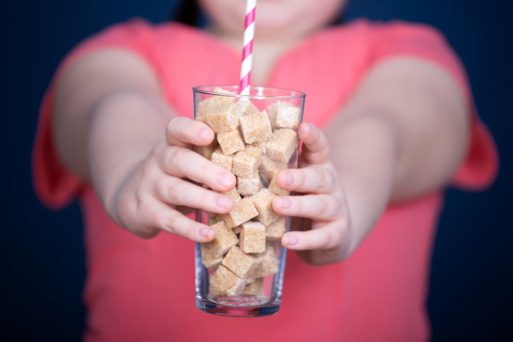 Person holding glass full of sugar cubes