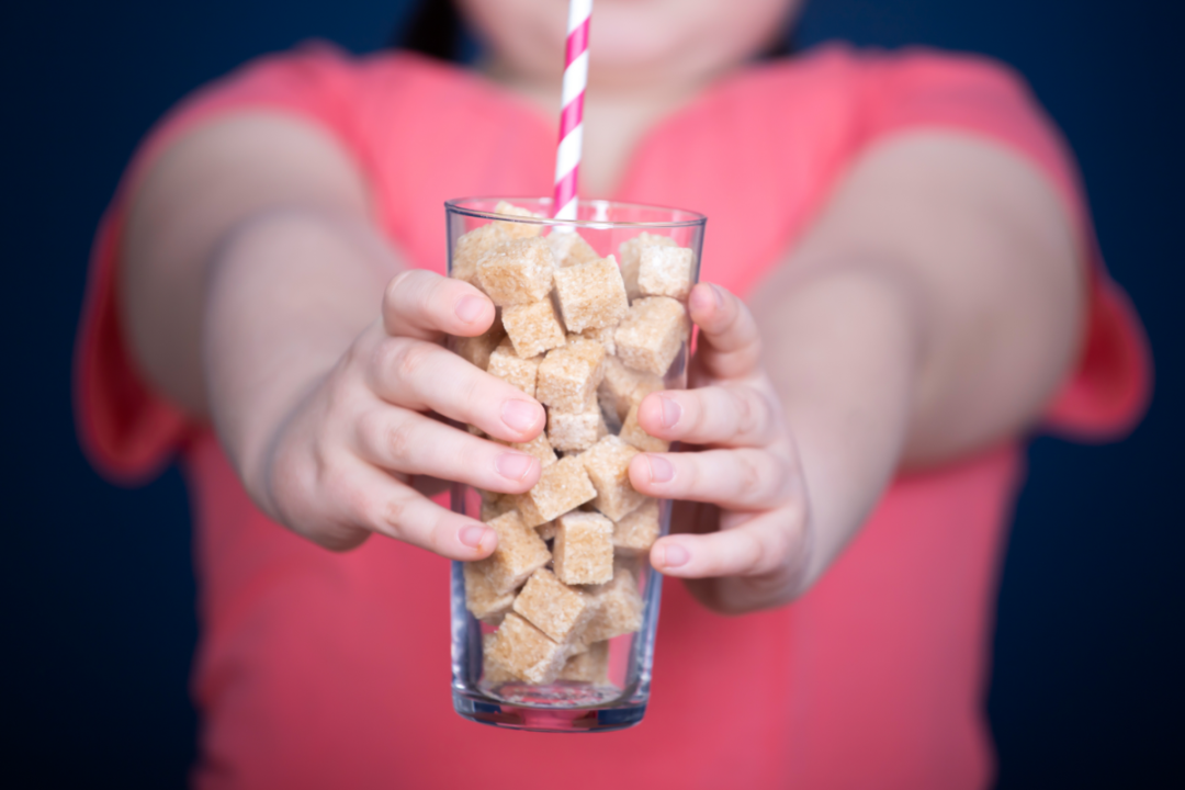 Person holding glass full of sugar cubes