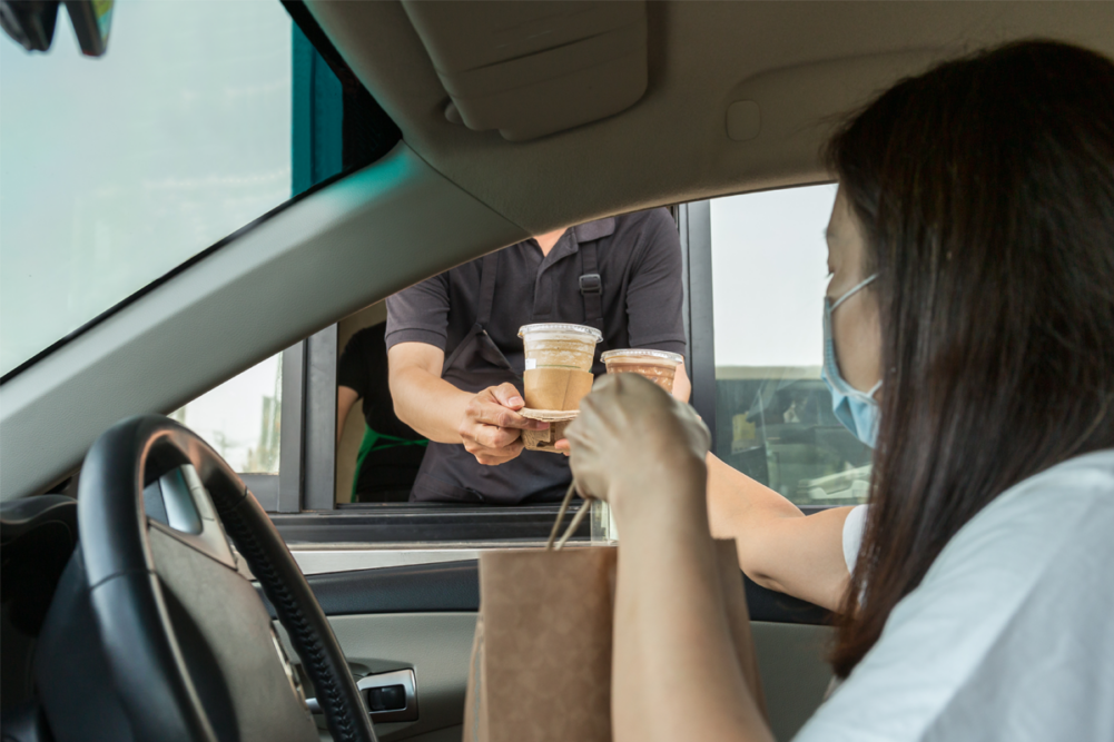 Person getting an order from a drive thru window