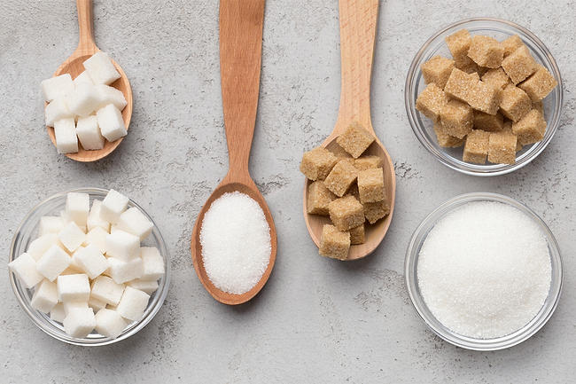 Sugar grains and cubes in a spoon