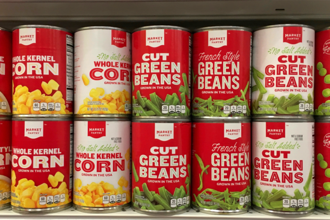 Corn kernels in cans on a supermarket shelf