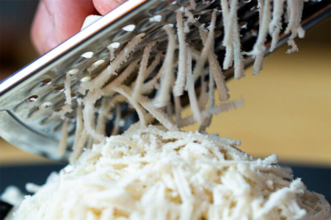 Mozzarella shreds on a grater