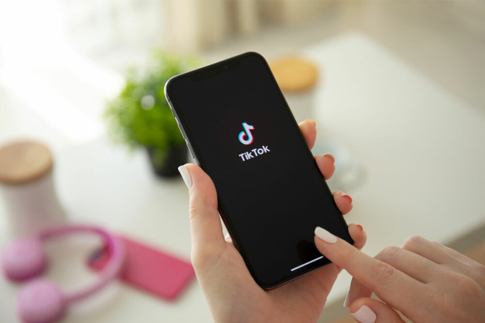 Woman holing phone open to TikTok app