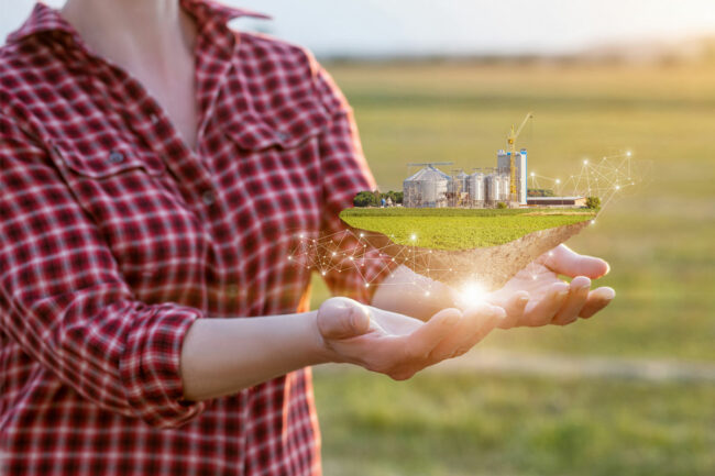 farmer holding miniature farm, sustainable farming concept