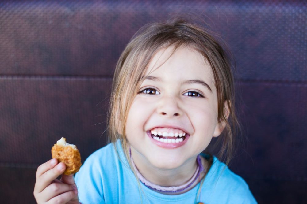 A child with a chicken nugget