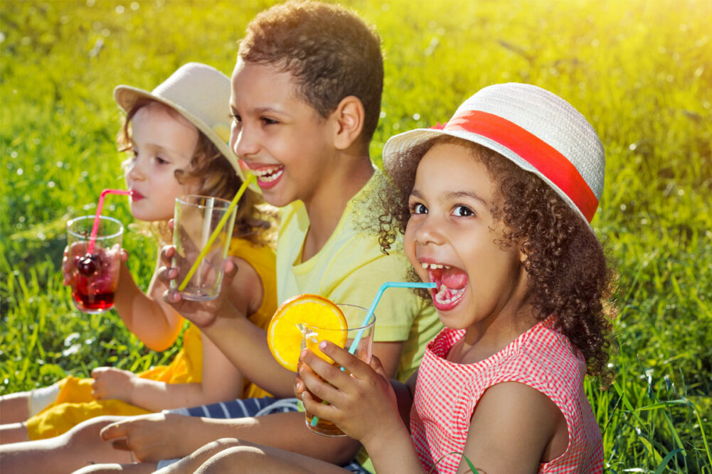 Children drinking juice in a park