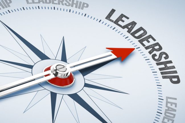Compass hand pointing toward leadership