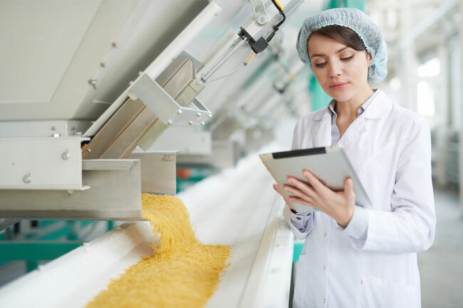 Worker inspecting macaroni in a factory