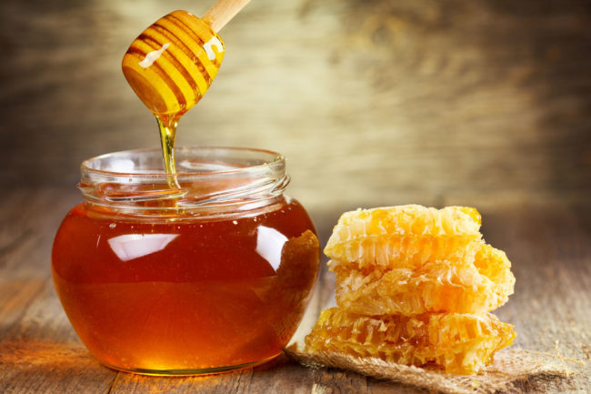 Jar of honey with a honeycomb