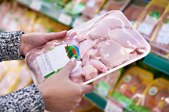 Woman buying chicken at the grocery store