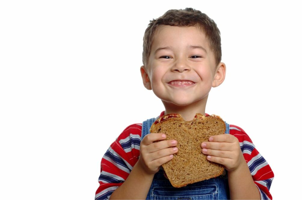 Child eating whole grain sandwich