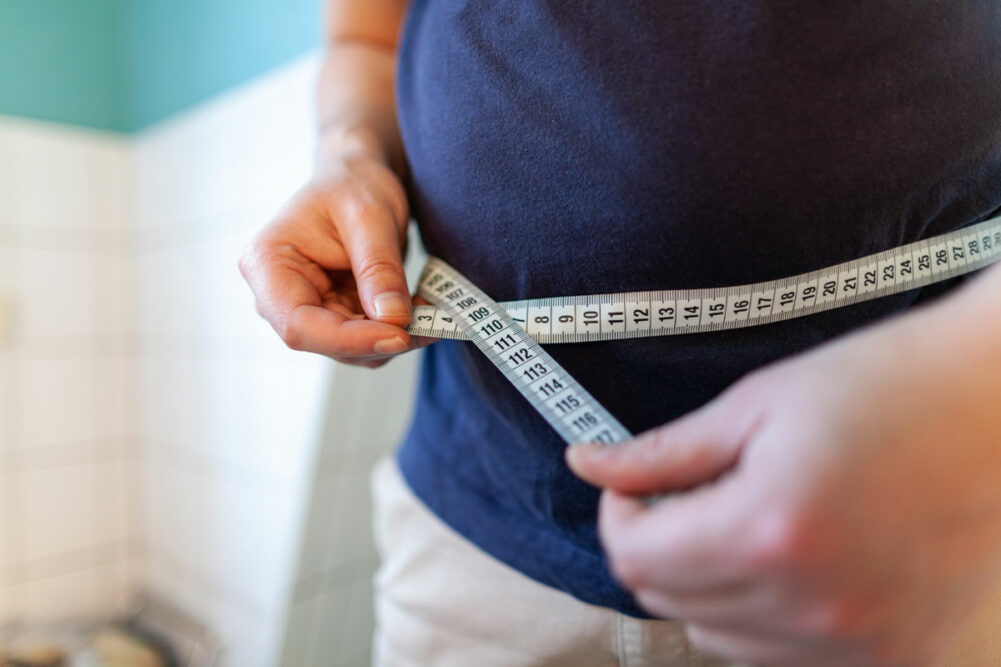 person measuring waist