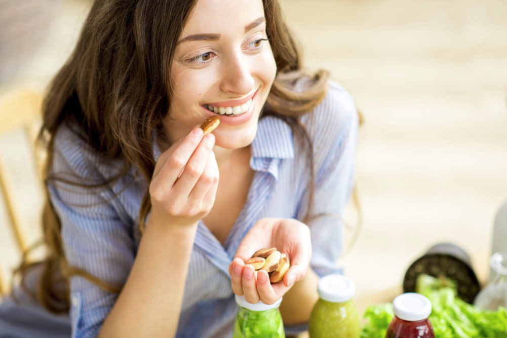 Woman snacking on Brazil nuts